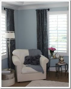 a living room with blue walls and white furniture