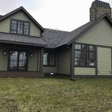 a house that is in the grass with a clock tower on it's roof