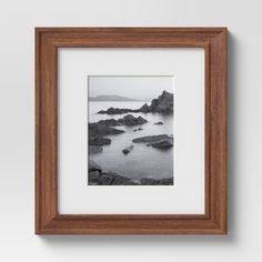 a black and white photo hanging on the wall next to a wooden frame with water in it