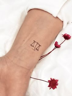 a woman's arm with a tattoo on it that has a scale and flowers