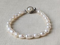 "A beautiful vintage bracelet made of strung white pearls with a lovely round clasp. There are natural imperfections in some of the pearls. Please look at all the pictures because they are part of the description. Thank you! It measures 8\" in length." Adjustable Classic Pearl Necklace For Wedding, Vintage Round Pearl Bracelet Gift, Vintage White Pearl Bracelet For Anniversary, Vintage Pearl Bracelet As Gift, Classic Pearl Bracelet With Round Beads As Gift, White Single Strand Pearl Bracelet For Anniversary, Single Strand Pearl Bracelet, Classic Adjustable Pearl Drop Bracelet, Classic Adjustable Pearl Bracelet With Pearl Charm