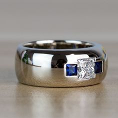 a diamond and blue sapphire ring on a table