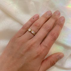 a woman's hand with a three stone ring on top of her left hand