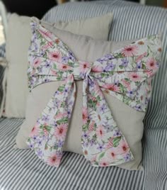 a pillow with a bow on it sitting on a bed