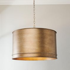 a light fixture hanging from a ceiling in a room with white walls and wood flooring