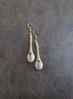 Cowrie shell and gold wire dangle earrings Cowrie Shell Earrings, African Inspired Jewelry, Afrocentric Jewelry, Mid Century Earrings, Afrocentric Earrings, Africa Earrings, Handmade Jewelry Ideas, Cowry Shell, African Earrings