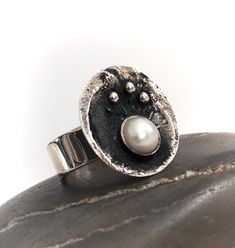 The most stunning and quite unique Silver and Pearl Danish Swedish / modernist / brutalist styled ring. The ring is hallmarked 925 and depicts a bowl or cauldron containing a pearl and smaller silver balls. Very unusual and quite striking and in perfect condition.  The ring is an English size P and a 7.5 US. The pen is just for scale and not included. Please feel free to ask any questions, I'm happy to help, and many thanks for visiting our new Etsy store. Hand Cast Modernist Ring As Gift, Modernist Hand Cast Ring As Gift, Hand Cast Modernist Ring, Brutalist Sterling Silver Ring For Anniversary, Hand Forged Sterling Silver Modernist Rings, Modernist Hand Forged Sterling Silver Rings, Brutalist Ring With Oxidized Finish As Gift, Brutalist Oxidized Finish Ring For Gift, Brutalist Oxidized Finish Ring As Gift