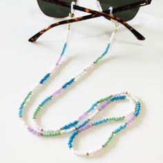 Pastel beaded sunglasses holder, Multicolor beaded sunglasses cord, Sunglasses necklace, Colorful glasses holder, Sunglasses strap Beautiful fashion trend sunglasses beaded string This sunglass strap is lightweight, comfortable to wear and secures your sunglasses on your neck. Fashion trend accessory for the summer! Total length is 70cm / 27.7 inches. Beautifully packaged and ready for gift giving. JEWELRY CARE: Please take care of your jewelry do not wear in the shower, swimming pool, or to bed White Adjustable Glasses Chains For Summer, Trendy White Glasses Chains With Colorful Beads, Trendy White Glasses Chains For Festival, Summer Necklace With Adjustable Chain And Round Beads, White Glasses Chains As Summer Gift, White Summer Glasses Chains, White Glasses Chains For Summer, Summer White Glasses Chains, White Glasses Chains For Summer Gift