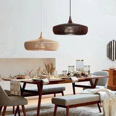 a dining room table with chairs and lights hanging from the ceiling