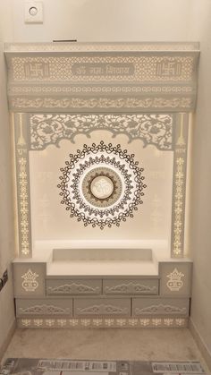 a white and gray room with an intricate design on the wall, built into the floor