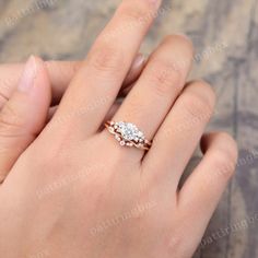 a woman's hand with a diamond ring on top of her finger and two diamonds in the middle