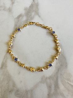 "Perfect worn on its own or layered with our other bracelets. 18k gold filled. Cubic zirconia 7\" length Ready to ship *18k gold filled is a more affordable alternative to solid gold jewelry. Gold filled is a layer of gold bonded onto a base metal with heat and pressure that contains 100+ times more gold than gold plated jewelry.  *It is very durable and tarnish resistant.  *With proper care, gold filled jewelry can last several years. Avoid contact with harsh chemicals, perfumes, water, etc.  *Gold filled jewelry can be worn by people with sensitive skin because it is hypoallergenic, lead free and nickel free." Gold Star-shaped Celestial Bracelets, Gold Star-shaped Celestial Bracelet, Celestial Gold Star Bracelets, Blue And Gold Bracelets, How To Layer Bracelets, Gold And Blue Aesthetic, Gold And Blue Jewelry, Tiffany Bracelet Stack, Blue And Gold Jewelry