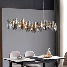 a dining room table with chairs and a chandelier hanging from it's ceiling