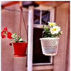 two hanging flower pots with flowers in them