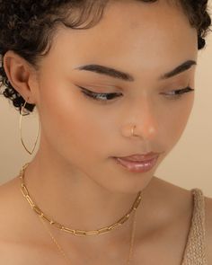 a close up of a woman wearing large gold hoop earrings and a choker necklace