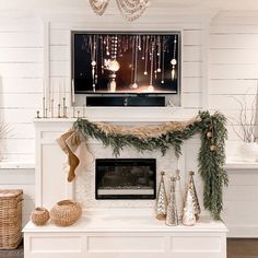 a fireplace decorated for christmas with garland and stockings on the mantel above it is a flat screen tv