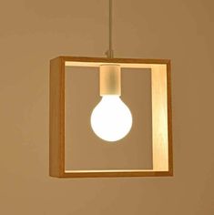 a light bulb hanging from the ceiling in a square wooden frame with a white light on it