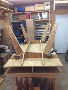 an unfinished table in a garage surrounded by boxes