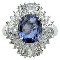 an oval blue and white stone surrounded by diamonds in a clustered halo style ring