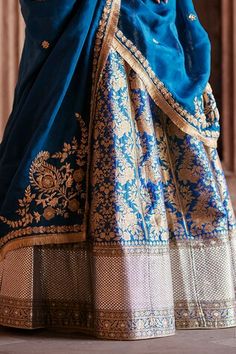 Peacock blue flared katan silk brocade banarasi kali lehenga with all over mughal bloom pattern and hand embroidered border. Paired with a half sleeves jewel neck padded blouse with intricate zardozi vine embroidery on the neckline, sleeves and blossom zardozi embroidered organza dupatta with kiran lace border embellishments. - Aza Fashions Blue Lehenga With Dupatta, Transitional Blue Lehenga With Dupatta, Transitional Season Blue Lehenga With Dupatta, Blue Silk Anarkali Set With Pallu, Blue Choli With Dupatta For Transitional Season, Transitional Blue Raw Silk Lehenga, Blue Anarkali Set With Traditional Drape And Pallu, Blue Silk Anarkali Set With Traditional Drape, Blue Silk Sharara With Traditional Drape