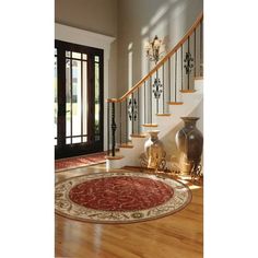 an entryway with stairs, vases and rug on the floor in front of it