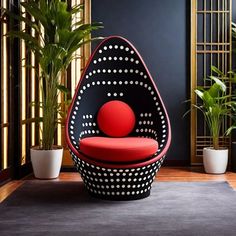 a black and red chair sitting on top of a rug next to potted plants