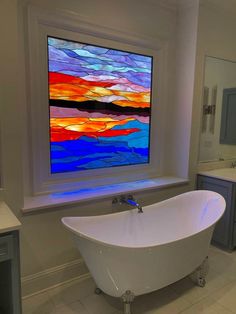 a bath tub sitting under a window next to a sink