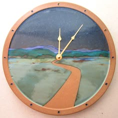 a clock that is on the side of a wall with a road going through it