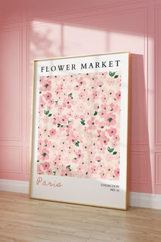 a pink flower market poster on the floor in front of a pink wall and wooden floor