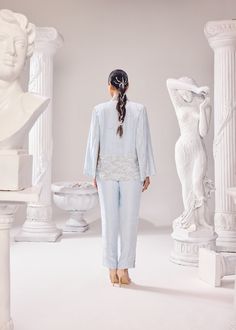 The Audrey Jacket Pant set is a 'bliss of summer air', with intricatly hand embroidered pearl detail with other fine materials all over the jacket and side seam of the pants. This ensemble has a 3D net detailing complimenting linear artwork perfectly juxtaposed together exhibiting impeccable couture craftsmanship. This outfit is a perfect fit to dance away the cocktail night or hit the reception party! Colour: Ice Melt Material: Opara- jacket, Opara- pants No of components: 3 Surface Ornamentation: Hand Embroidery Care Instructions: Dry Clean Shipping Time: 3-4 weeks Spring Embellished Long Sleeve Pant Set, Embellished Long Sleeve Pant Set For Spring, Spring Embellished Fitted Pant Set, Fitted Embellished Pant Set For Spring, Elegant Sets With Set-in Sleeves And Straight Pants, Embellished Pant Set For Spring Wedding, Embellished Pant Set For Wedding, Spring Wedding Embellished Pant Set, Spring Silk Pant Set With Long Sleeves