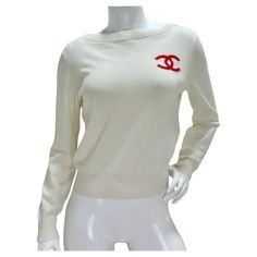 Indulge in timeless sophistication with the Chanel 2019 La Pausa Cashmere Sweater. This ivory crewneck sweater, crafted from sumptuous cashmere, exudes luxury and comfort. The iconic red interlocking 'C' logo on the front adds a signature touch of Chanel elegance, while the bold 'La Pausa' lettering on the back, accompanied by a red CC Chanel logo, infuses a distinctive charm. Classic and chic, this sweater seamlessly blends versatility with a nod to Chanel's enduring legacy. Elevate your style effortlessly with this soft and luxurious piece, a must-have for those who appreciate the perfect fusion of fashion and comfort. Style this with a pair of Fendi pants, some Prada flats and a Louis Vuitton handbag to complete the look. In excellent condition with no signs of wear, please see photos. Luxury Fitted Red Sweater, Chanel Clothes, Prada Flats, Chanel Pants, Fendi Pants, Chanel Sweater, Lirika Matoshi, Chanel 2019, Chanel Shirt