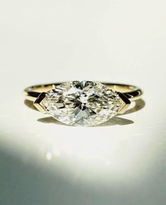 an oval cut diamond ring on a white surface