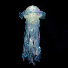 a jellyfish hanging in the dark with its head turned to look like it is floating