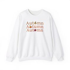 Get cozy in our Gildan 18000 sweatshirt, featuring a unique fall-themed design! The word 'Autumn' is repeated three times in vibrant orange, each word creatively incorporating a seasonal icon--a leaf, a scarecrow, and a pumpkin--into the lettering. This soft, durable sweatshirt is perfect for layering as the temperatures drop. Show off your love for the autumn season with this eye-catching, comfortable piece that celebrates all the best parts of fall." Ideal for any situation, a unisex heavy ble Orange Crew Neck Hoodie For Fall, Letter Print Sweater For Fall Streetwear, Letter Print Sweater For Streetwear In Fall, Casual Sweater With Graphic Print For Fall, White Cotton Sweater For Fall, Fall Graphic Print Crew Neck Hoodie, Fall Graphic Print Hoodie With Crew Neck, Fall Hoodie With Ribbed Cuffs, Relaxed Fit T-shirt With Ribbed Cuffs For Fall