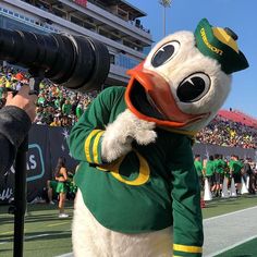 a mascot with a camera in his hand at a football game