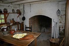 an old fashioned kitchen with a fireplace in it