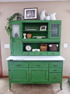 a green hutch with white counter top and drawers