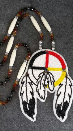 a beaded native american dream catcher necklace with beads and glass beads on a gray background