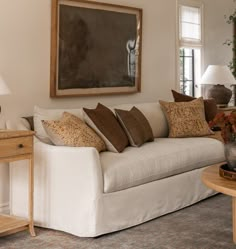 a living room filled with furniture and a painting on the wall