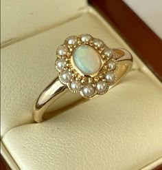 a gold ring with white pearls on it