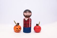 a wooden doll and two pumpkins on a white background