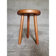 a wooden stool sitting on top of a cement floor