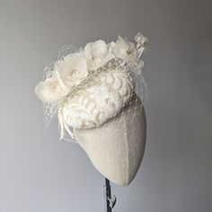 READY TO SHIP TODAY ☀ Follow this link for more beautiful choices from 'Indigo Hats'  https://www.etsy.com/shop/IndigoHats ☀ Handmade with care by Jaine. This charming hat is handblocked in a natural creamy sinamay straw.   It has a subtle sequin applique in ivory and a bough of beautiful silk milinery flowers, also in ivory.  A coordinating ivory veiling with a flurry of veiling around the back completes the look.   The base of the hat measures approx. 7" across.  It has a comfortable elastic to hold securely on and is lined in silk. Please let me know if you have any questions at all - I am always here to help:) - Jaine ☀ Find your perfect fascinator here from 'Indigo Hats' https://www.etsy.com/shop/IndigoHats ☀ Thank you for considering one of my headpieces for your special occasion! Vintage White Hat Headpiece, White Hat For Vintage Events, Wedding Costume Hats And Headpieces With Handmade Flowers, Elegant Wedding Hats And Headpieces With Handmade Flowers, White Curved Brim Fascinator For Vintage Events, Elegant White Hat For Vintage Events, Elegant White Hats For Vintage Events, Adjustable Wedding Fascinator, Adjustable Fascinator For Wedding