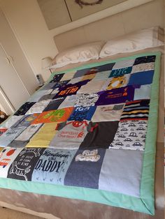 a bed with a quilt made to look like it has many t - shirts on it