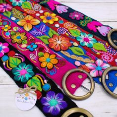 the colorful belt has flowers on it and is ready to be used as a keychain