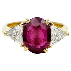 Ring Size: 6 This exquisite ring features a stunning and rare oval cut Burma ruby at its center, set in luxurious 18 karat yellow gold. The vibrant hue of the natural ruby radiates warmth and elegance, capturing attention with its rich color and captivating allure. Flanking the vivid center stone are two dazzling trillion-cut diamonds, adding a touch of brilliance and sophistication to the design. The combination of the fiery red ruby and the sparkling diamonds creates a striking contrast, enhancing the overall beauty of the ring. The 18 karat yellow gold setting provides the perfect backdrop for the gemstones, adding warmth and richness to the piece. Whether worn for a formal occasion or as part of your everyday wear, this oval red ruby and diamond ring is sure to leave a lasting and time Trillion Diamond Ring, Trillion Ring, Trillion Diamonds, Golden Rings, Ruby And Diamond Ring, Golden Ring, Red Diamond, Yellow Gold Setting, Fiery Red