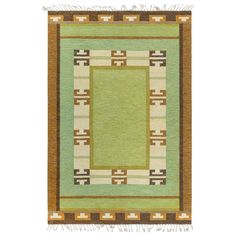 an area rug with green and brown accents on the border, in front of a white background