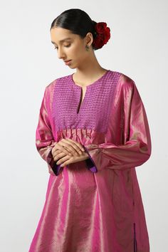 Pink dual toned silk short phiran tunic with contrast thread hand embroidered yoke, bead work highlights and puff sleeves.
Components: 1
Pattern: Hand Embroidered
Type Of Work: Thread and Bead Work
Neckline: Notched Round Neck
Sleeve Type: Puff Sleeves
Fabric: Two Tone Silk
Color: Pink
Other Details: 
Side pockets
Side slits detail
Frill sleeve borders
Note: The pant worn by the model is not for sale
Disclaimer: While the designer strives to recreate every piece as close to what is displayed on Silk Blouse With Embroidered Long Sleeves, Festive Chanderi Straight Kurta Top, Festive Blouse Piece With Embroidered Long Sleeves, Silk Long Sleeve Blouse With Resham Embroidery, Fitted Tunic With Resham Embroidery For Festive Occasions, Festive Blouse With Embroidered Sleeves For Eid, Festive Fitted Tunic With Resham Embroidery, Festive Raw Silk Kurta With Embroidered Sleeves, Eid Tunic Blouse With Resham Embroidery