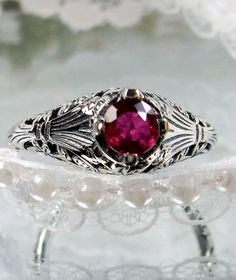 <> Made To Order This is a Victorian/Edwardian reproduction ring in sterling silver (Solid 10K and 14K gold option also now available) filigree with a natural red ruby gemstone solitaire. This full cut round cut red ruby gemstone is 4mm in diameter. The inside of the band is marked 925 for sterling (or 10K/14K if gold option selected). Notice the beautiful floral design of the filigree setting and band. This is a lovely rendition of an Antique filigree ring. A gift ring box is included and all r Heirloom Ruby Ring For Marriage, Silver Filigree Ring With Gemstone For Wedding, Antique Hallmarked Ruby Wedding Ring, Heirloom Style Ruby Gemstone Ring For Wedding, Heirloom Style Ruby Ring For Wedding, Antique Ruby Jewelry With Filigree, Victorian Ruby Gemstone Ring For Wedding, Victorian Ruby Ring With Filigree For Wedding, Vintage Ruby Jewelry For Anniversary