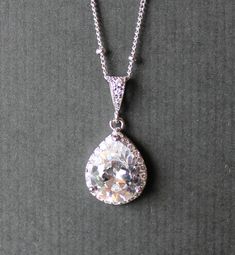 "Classic and elegant! Our 'Tamara' teardrop pendant is made with a sparkling multifaceted crystal pear and surrounded by a halo of matching Swarovski crystals set in a tarnish free rhodium base. We have used a matching 16.5\" rhodium plated fine cable chain, with a 2\" extender to complete this delicate necklace. PLEASE NOTE: This listing is for the necklace ONLY. 💙This item is also available in 18K Gold and 18K Rose Gold. ★★Items that are frequently bought together with the \"Tamara necklace\" Elegant Drop Jewelry With Halo Setting, Elegant Jewelry With Halo Setting In Drop Shape, Formal Teardrop Drop Necklace With Diamond Cut, Classic Teardrop Necklace With Elegant Design, Elegant Teardrop Halo Jewelry, Elegant Teardrop Halo Setting Jewelry, Elegant Pear-shaped Drop Necklace Gift, Pear Shaped Brilliant Cut Wedding Jewelry, Formal Teardrop Halo Jewelry